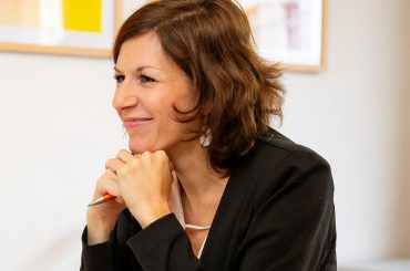 Anna Kauert sitzt am Schreibtisch